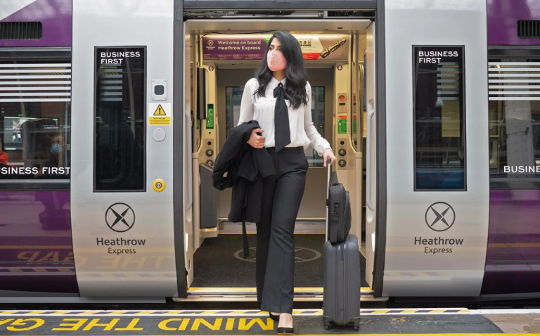 Woman stepping out of a business class carriage on heathrow express train