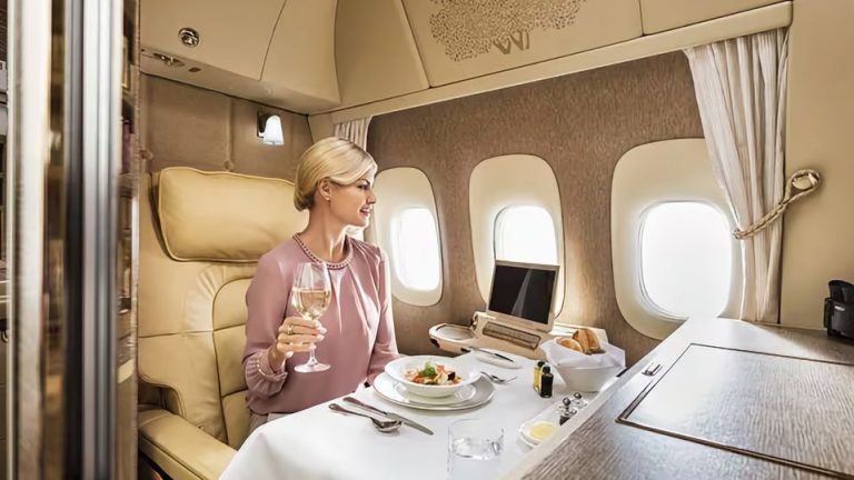 A woman enjoys premium dining with a glass of wine in Emirates' new designed first class suites