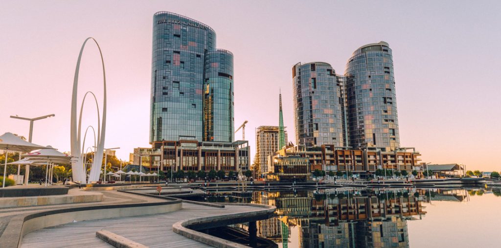 The Ritz-Cartlton Perth dominates the city skyline, set against a pink dusk sky.